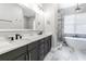 Bathroom with double vanity, quartz countertops, a soaking tub, and a tiled shower at 6010 Kipps Colony E Dr, Gulfport, FL 33707