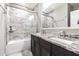 A bathroom featuring a bathtub/shower combo with a glass door, double sinks, and a granite vanity at 6010 Kipps Colony E Dr, Gulfport, FL 33707