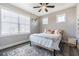A cozy bedroom featuring a ceiling fan and a bright window with a patterned rug at 6010 Kipps Colony E Dr, Gulfport, FL 33707
