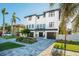 Elegant two-story home boasts a beautifully landscaped front yard and a paver driveway leading to a two-car garage at 6010 Kipps Colony E Dr, Gulfport, FL 33707