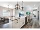 An open-concept kitchen showcasing an island with a farmhouse sink, granite countertops, and modern pendant lighting fixtures at 6010 Kipps Colony E Dr, Gulfport, FL 33707