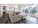 Bright living room with a cozy sectional sofa, hardwood floors, and sliding glass doors leading to a balcony at 6010 Kipps Colony E Dr, Gulfport, FL 33707