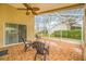 Relaxing screened porch with tile flooring, ceiling fan, and comfortable seating at 11917 Spindrift Loop, Hudson, FL 34667