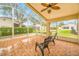 Spacious screened porch overlooks backyard, featuring a ceiling fan and comfortable seating at 11917 Spindrift Loop, Hudson, FL 34667