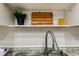 Close-up of a modern kitchen faucet, granite countertop, and stylish backsplash tiles at 1221 Drew St # E11, Clearwater, FL 33755