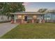 Charming bungalow with brick facade, well-manicured lawn, and a welcoming front porch at 1303 E Frierson Ave, Tampa, FL 33603