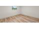 Simple bedroom with light wood flooring and a window at 1601 Spring Ln, Brandon, FL 33510