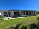 Home with solar panels, patio, and grassy backyard at 1707 New Bedford Dr, Sun City Center, FL 33573