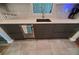 Modern kitchen with dark cabinetry, quartz countertops, and a farmhouse sink at 1707 New Bedford Dr, Sun City Center, FL 33573