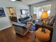 Open living room with comfortable seating and hardwood floors, offering a view to the kitchen at 1707 New Bedford Dr, Sun City Center, FL 33573