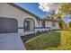 Renovated home exterior boasts a modern gray garage door and stylish landscaping at 4290 Yucatan Cir, Port Charlotte, FL 33948