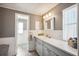 Modern bathroom with gray vanity, marble countertop, and bathtub at 5613 Pawnee St, Zephyrhills, FL 33542