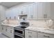 Gourmet kitchen featuring stone countertops, a stainless steel range, and white cabinetry at 611 June Lake Ln, Brandon, FL 33510