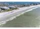 Aerial view of beach and ocean, showing waves, sandy shore, and distant buildings at 6767 Sunset Way # 301, St Pete Beach, FL 33706