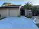 Two-car garage and front entry of condo with landscaping at 9744 Lake Seminole E Dr, Largo, FL 33773