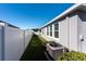 Spacious backyard with a grassy area, white vinyl fence, and AC unit at 12512 Brick Cobblestone Dr, Riverview, FL 33579