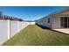 Backyard view showing a large grassy area and a white fence at 12512 Brick Cobblestone Dr, Riverview, FL 33579
