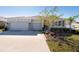 Charming single-Gathering home featuring a three-car garage, neutral paint, and manicured landscaping at 12512 Brick Cobblestone Dr, Riverview, FL 33579
