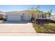 Two-story house with a three-car garage, landscaping, and a paved driveway at 12512 Brick Cobblestone Dr, Riverview, FL 33579