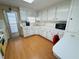 White kitchen cabinets, yellow appliances, and a wood-look floor at 2331 Belleair Rd # 611, Clearwater, FL 33764