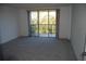 Spacious bedroom with carpet flooring and sliding glass doors to balcony at 2699 Seville Blvd # 605, Clearwater, FL 33764
