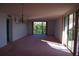Living room with pink carpet, chandelier, and balcony access at 2699 Seville Blvd # 605, Clearwater, FL 33764