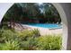 Community pool with surrounding landscaping and seating at 2699 Seville Blvd # 605, Clearwater, FL 33764