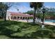 Community pool surrounded by lush lawn and trees at 2699 Seville Blvd # 605, Clearwater, FL 33764
