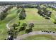 Aerial view of a golf course with a cart path and golf carts at 334 Caloosa Palms Ct, Sun City Center, FL 33573