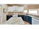Modern kitchen with white and blue cabinets and granite countertops at 334 Caloosa Palms Ct, Sun City Center, FL 33573