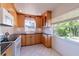 Bright kitchen featuring light wood cabinets, white appliances, and a window overlooking the backyard at 3873 21St N Ave, St Petersburg, FL 33713