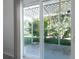 Patio view through sliding glass doors to the yard with lush landscaping and trellised patio covering at 3873 21St N Ave, St Petersburg, FL 33713