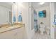 Neutral bathroom featuring a granite vanity countertop, tub-shower combo, and coastal-themed decor at 399 150Th Ave # A203, Madeira Beach, FL 33708