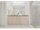 Bright bathroom featuring dual sinks, a granite countertop, a large mirror, and a glass-enclosed shower at 399 150Th Ave # A203, Madeira Beach, FL 33708