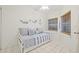 Neutral bedroom with a daybed, tile floors, a ceiling fan, and natural light from the two windows at 399 150Th Ave # A203, Madeira Beach, FL 33708