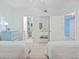 Bright bedroom featuring two beds, a mirrored closet, and ensuite bathroom and hallway access at 399 150Th Ave # A203, Madeira Beach, FL 33708