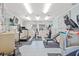 Spacious home gym featuring multiple exercise machines, fitness equipment, and a wall-mounted television at 399 150Th Ave # A203, Madeira Beach, FL 33708