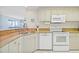 Updated kitchen with granite counters, white cabinets, and stainless steel appliances overlooking the living space at 399 150Th Ave # A203, Madeira Beach, FL 33708