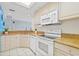 Updated kitchen featuring granite counters, white cabinets, and a view into the adjacent dining and living areas at 399 150Th Ave # A203, Madeira Beach, FL 33708