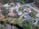 Aerial view of a home with a screened pool in a residential neighborhood near a pond at 24034 Geese Cir, Land O Lakes, FL 34639