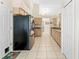 Spacious kitchen featuring light cabinets, tile floors, and a modern black refrigerator at 24034 Geese Cir, Land O Lakes, FL 34639