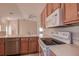 View of kitchen with wood cabinets, white appliances, and a breakfast bar at 29417 Caddyshack Ln, San Antonio, FL 33576