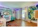 Bedroom with a full-size bed, leafy wall decor, and a workspace at 310 Washington Ave, Oldsmar, FL 34677