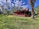 Red house with large porch and solar panels at 5661 Tower Rd, Land O Lakes, FL 34638