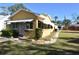 Yellow house with a green roof, awnings, and a yard at 1360 Prescott S St, St Petersburg, FL 33712