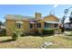 Yellow house with a green roof, awnings, and a yard at 1360 Prescott S St, St Petersburg, FL 33712