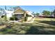 Yellow house with a green roof, awnings, and a yard at 1360 Prescott S St, St Petersburg, FL 33712