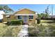 Yellow house with a green roof, awnings, and a yard at 1360 Prescott S St, St Petersburg, FL 33712
