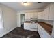 Galley kitchen with white cabinets and laminate flooring at 1360 Prescott S St, St Petersburg, FL 33712
