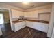 Efficient kitchen with white cabinets, laminate floor, and appliances at 1360 Prescott S St, St Petersburg, FL 33712